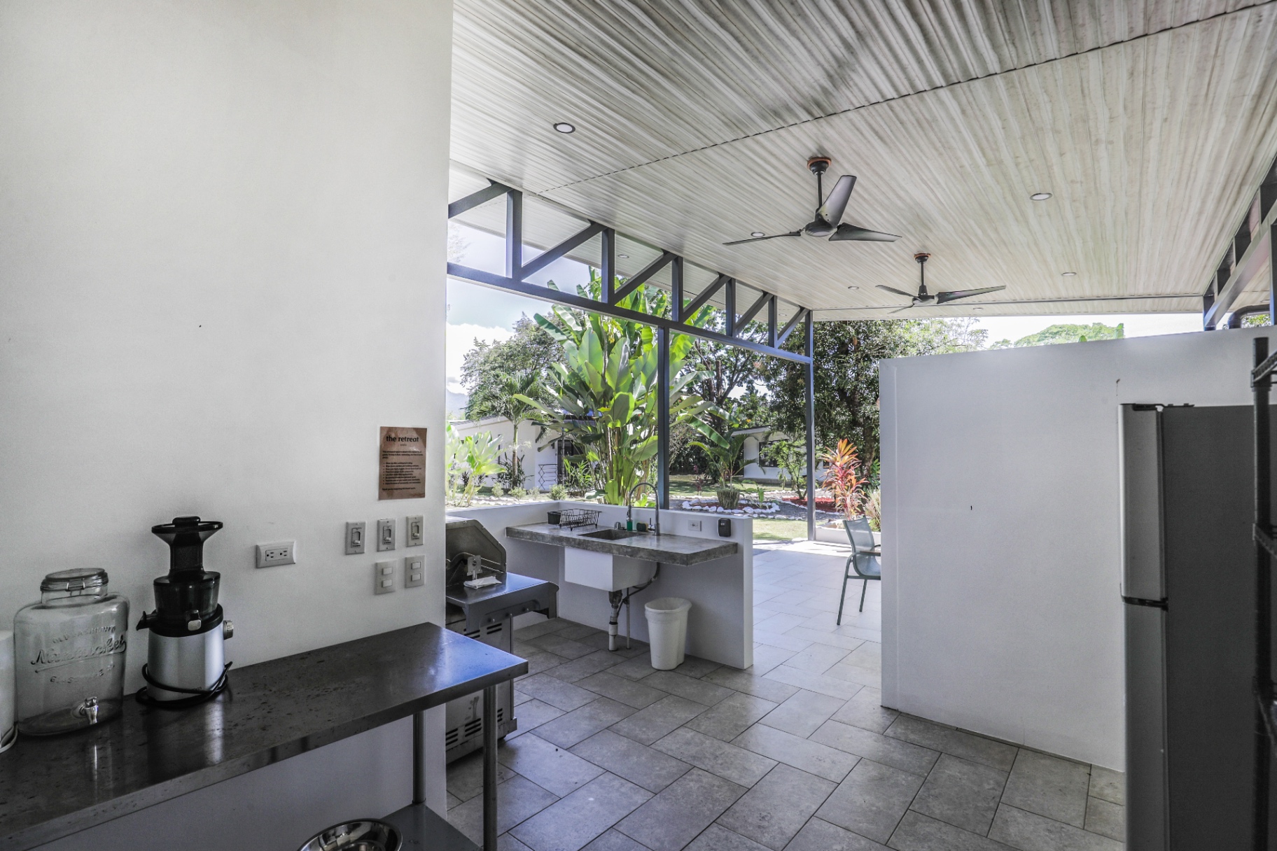 Shared outdoor kitchen and BBQ area with stainless grill, sink and juicer at The Retreat Uvita