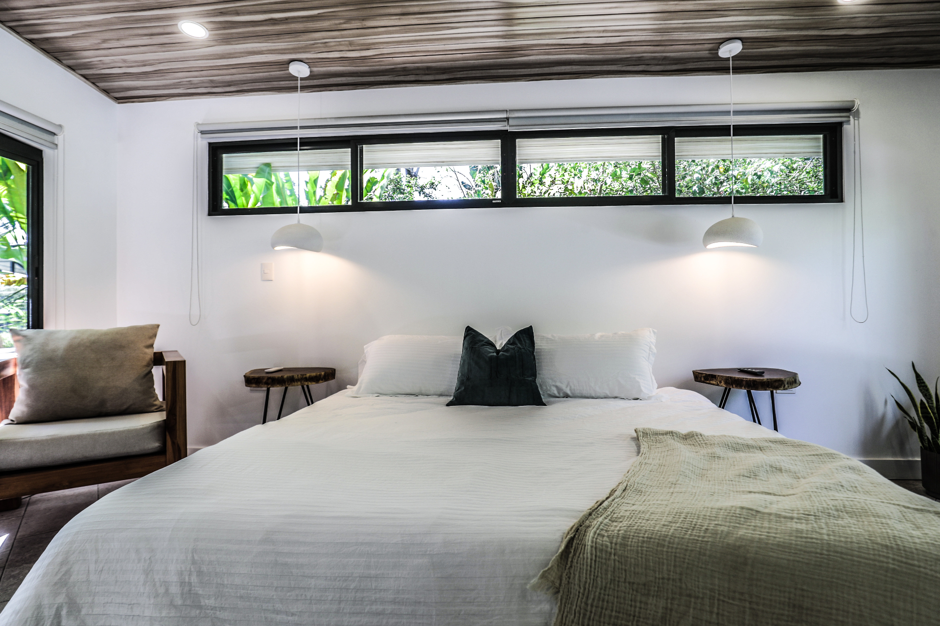King bedroom with wood-slat ceiling, pendant lights and clerestory garden windows in Unit 4 at The Retreat Uvita