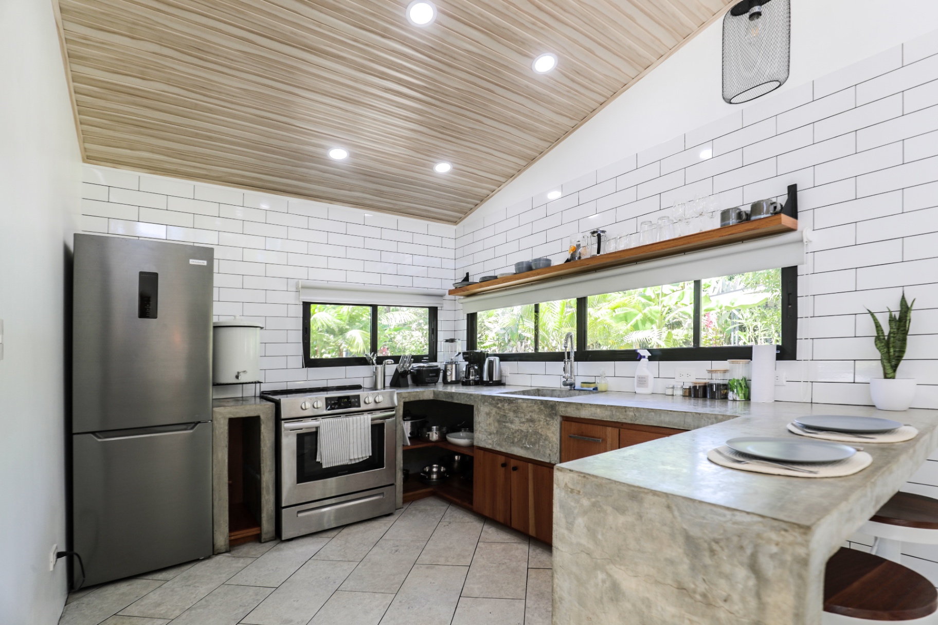 Full in-casita kitchen with concrete counters, stainless stove, oven and refrigerator in Unit 1