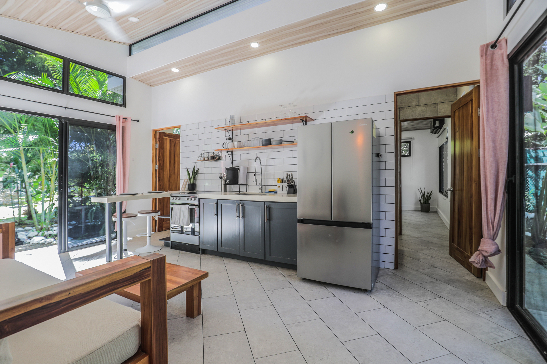 Full in-casita kitchen with white subway tile, concrete counters, stainless fridge and stove in Unit 4