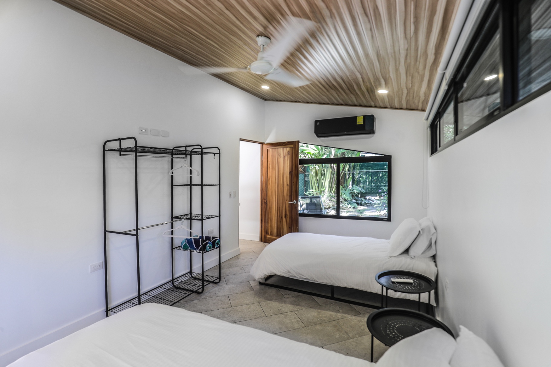Twin bedroom with two beds, hanging closet, AC and picture window to the tropical garden in Unit 4