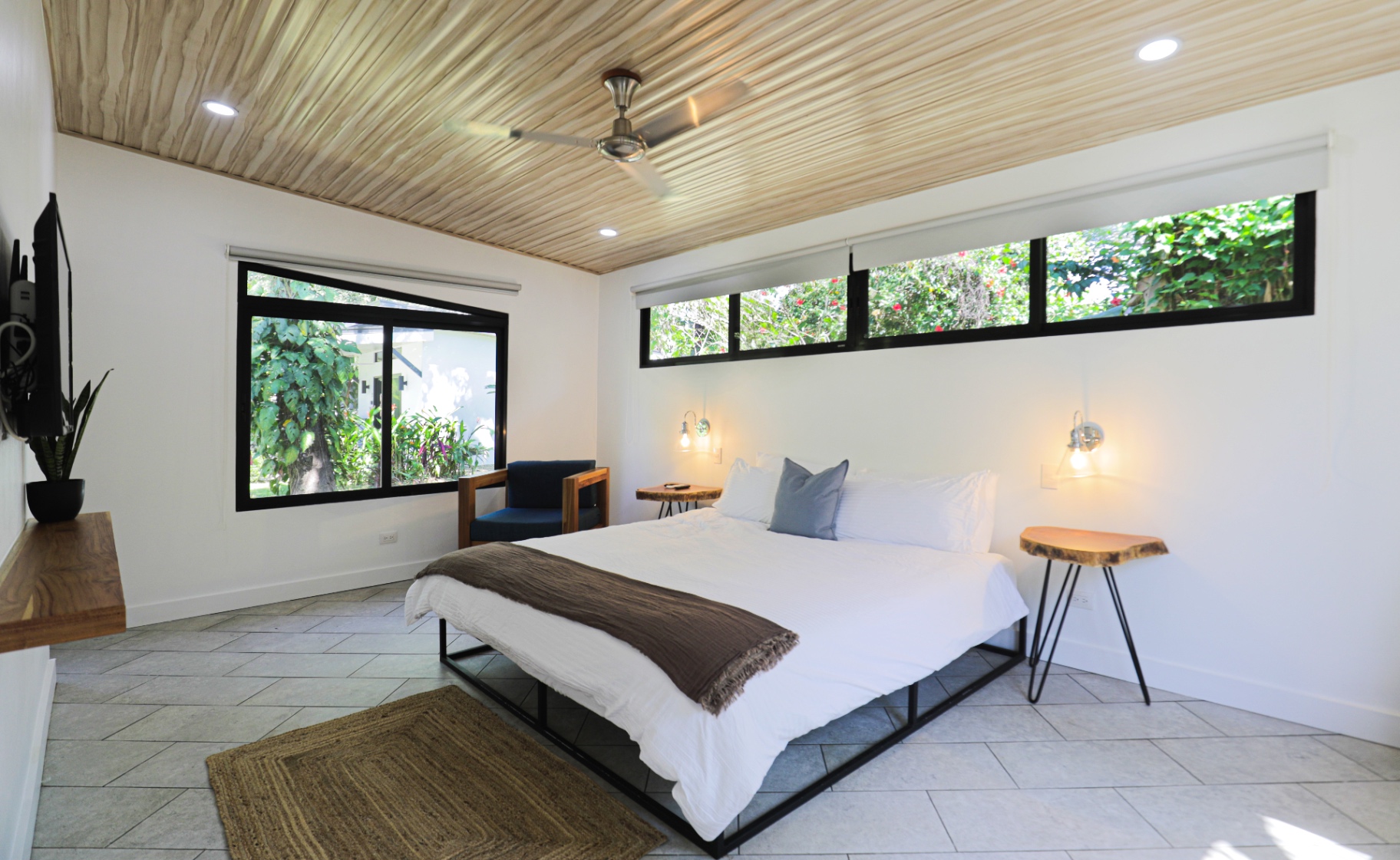 King bedroom with garden-view windows, soft cotton linens and wood-slat ceiling in Unit 1 at The Retreat Uvita